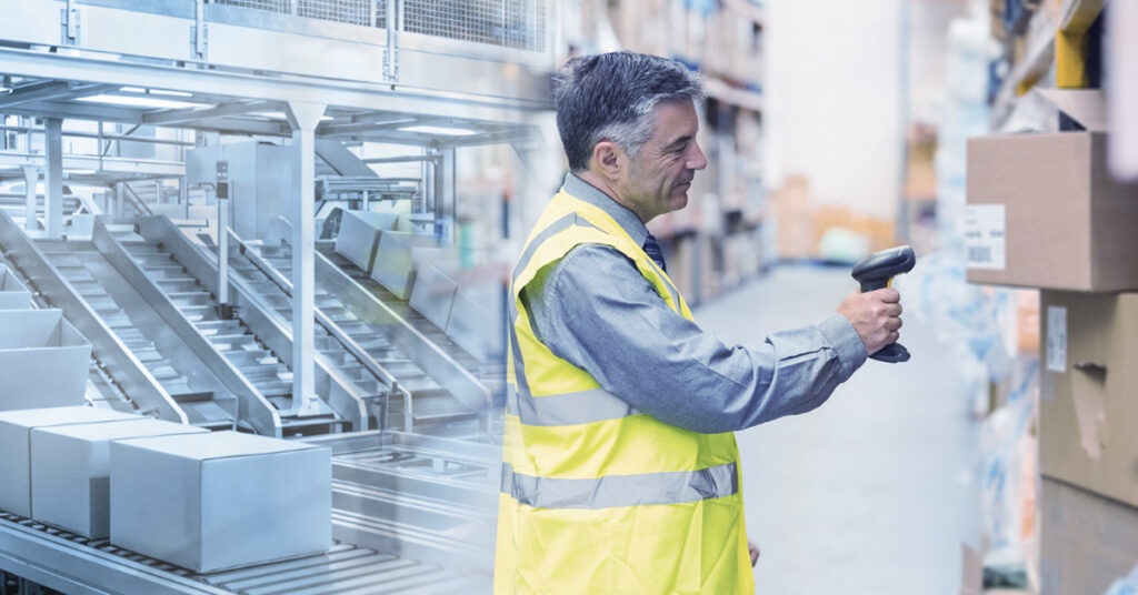 Funcionário escaneando caixas em armazém logístico ao lado de sistema automatizado de esteiras transportadoras